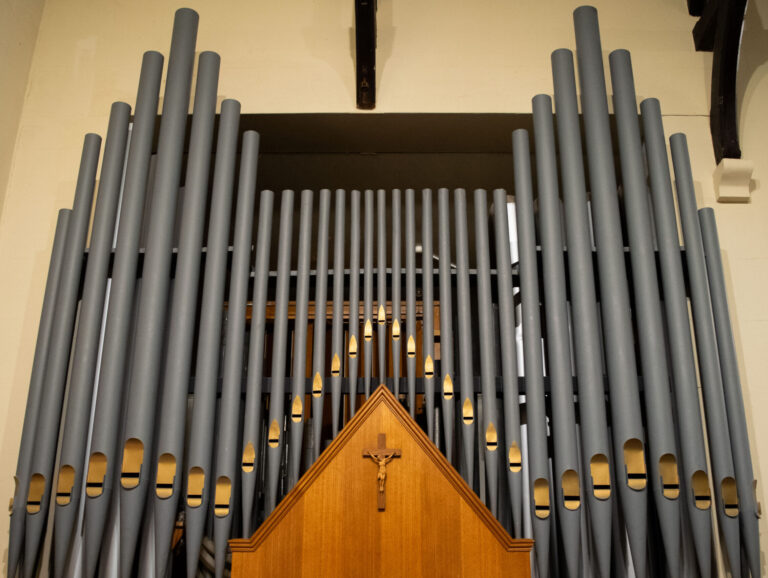 St Andrew's Church organ pipes with small wooden panel depicting Jesus on the Cross