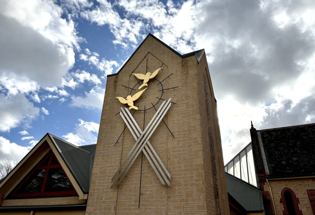 Artwork on Parish Centre, Saint Andrew's cross rendered with two gold birds