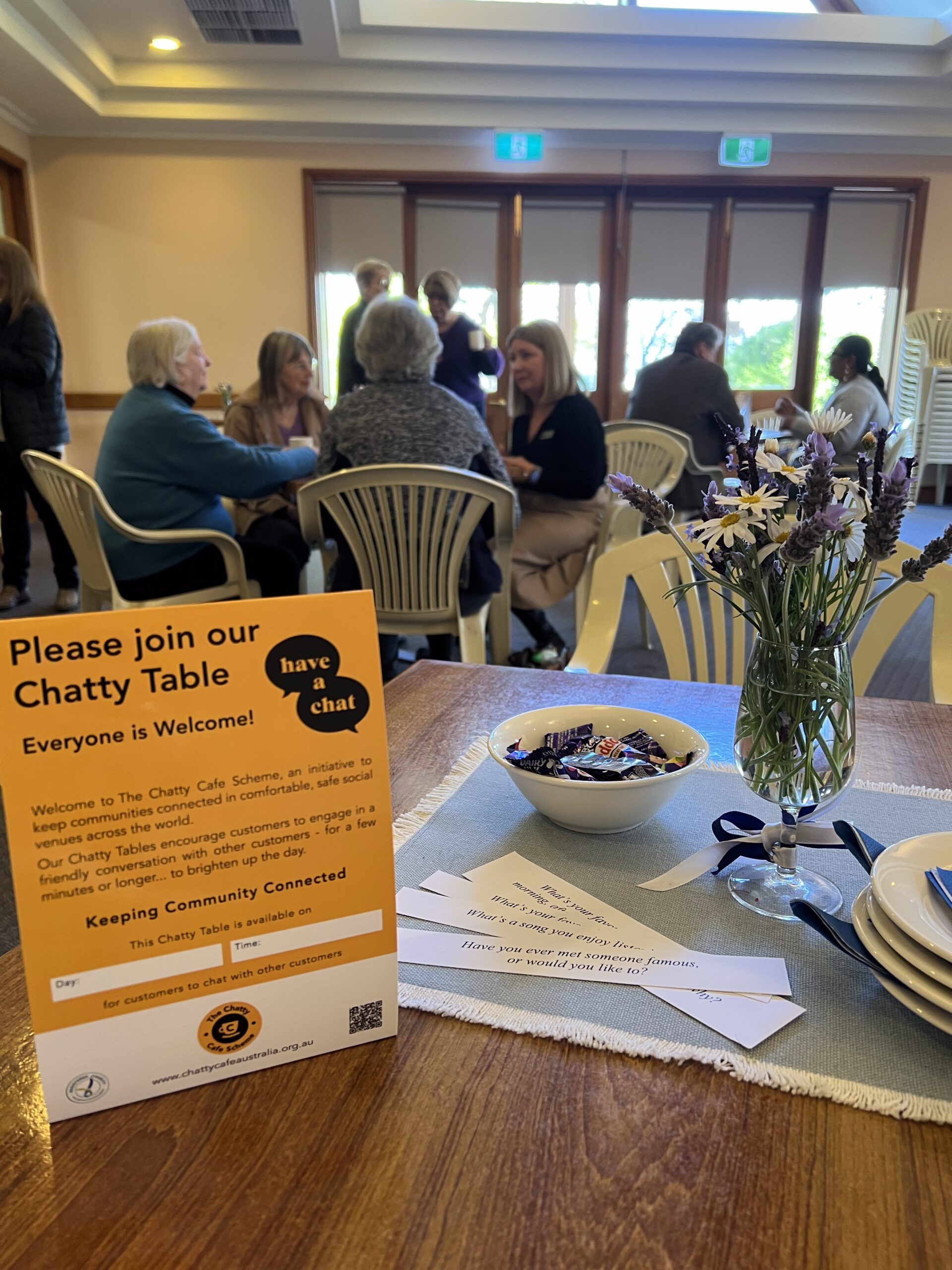 Entry table in Parish Centre with sign welcoming the community to Chatty Cafe
